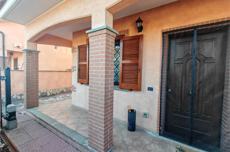 Portico con giardino piastrellato su tre lati